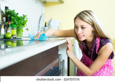 Attractive Woman Cleaning Furniture In Kitchen With A Rag