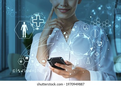 Attractive Woman Doctor Working On Smartphone In Hospital. Neural Treatments, Surgery And Medicine Research Of Human Health. Med Icons Drawn On Glass Screen On Foreground Including Pills, Body Parts