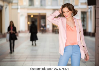 Attractive Woman Dressed In Trendy Outfit Walking In Street Of Milan On Shopping, Fashionista, Holding Purse, Wearing Pink Jacket, Jeans, Summer Elegant Style, Smiling, Happy, Looking In Camera