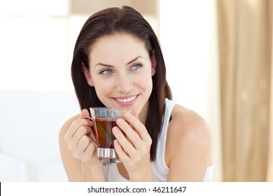 Attractive Woman Drinking Tea Sitting On Her Bed