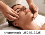 Attractive woman enjoying face massage, closeup. Beauty procedure