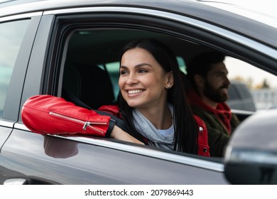 Attractive woman is enjoying her journey while sitting on passenger seat near her husband in car. Lady is looking through the window and dreaming  - Shutterstock ID 2079869443