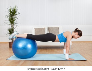 Attractive Woman Exercising With Exercise Ball At Home.