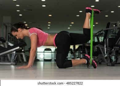 Attractive Woman Exercising With A Resistance Band On Floor In Gym As Part Of Fitness Training