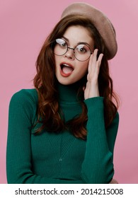 attractive woman in green in a green sweater glasses elegant style pink background
