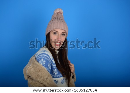 attractive woman in a hat in a fur coat on a blue background