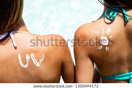 Attractive woman with healthy skin applying sunscreen for healthy tanning