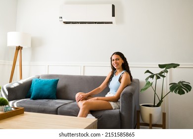 Attractive Woman In Her 20s Relaxing In The Sofa During The Summer And Enjoying The Air Flow Of The Ac Unit