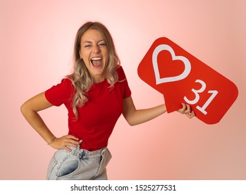 Attractive woman holding heart symbol of like and love social media notification icon happy with followers and fans on the internet. Girl loving having likes In social media obsession and networking. - Shutterstock ID 1525277531