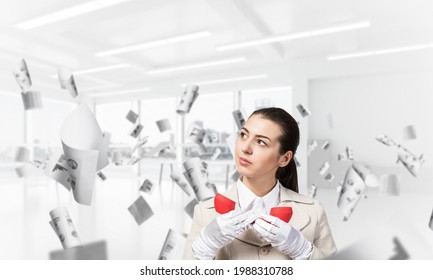 Attractive Woman Holding Vintage Red Phone In Office With Flying Paper Documents. Elegant Operator In White Business Suit Posing With Telephone. Hotline Telemarketing And Business Communication.