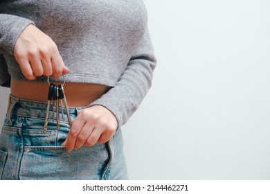 Attractive woman in jeans holding a bunch of keys. Keys near the pocket. Holding in hands house and bunch of keys.