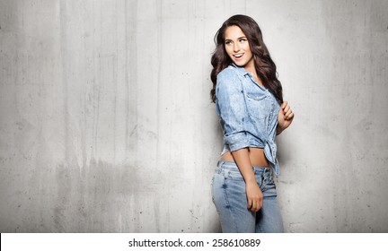 Attractive woman in jeans touching her hair