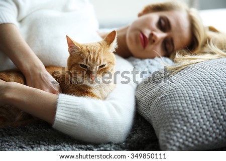 Attractive woman laying with red cat