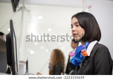 Attractive woman officer sitting at check in counter desk at the airport. business airline service concept