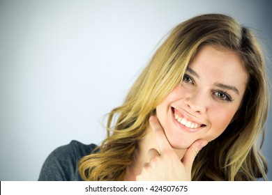 attractive woman on plein background shot in studio with soft lights with an interesting expression and dramatic lighting