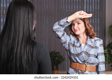 Attractive woman in a plaid suit is having a wingwave session with a client. Certified coach uses an integrative neuropsychological method aimed at working with destructive emotional states - Shutterstock ID 2242429101