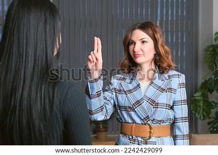 Attractive woman in a plaid suit is having a wingwave session with a client. Certified coach uses an integrative neuropsychological method aimed at working with destructive emotional states