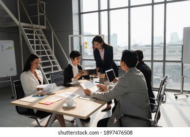 Attractive Woman Present Her Analysis To Young Lady Team Leader  In Business Meeting With Diversity People At Modern Office Room, Young Power, Woman Leadership Concept