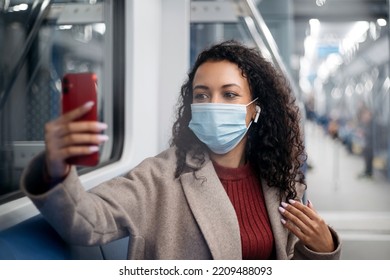 Attractive Woman In A Protective Mask Taking A Selfie In A Subway Car .