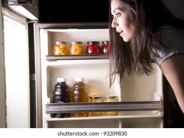 An Attractive Woman Raids The Refrigerator Late At Night Looking For A Food Snack