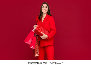 attractive woman in red suit with shopping bags sale on red background happy smiling long hair stylish fashion trend black friday - Shutterstock ID 2224862621