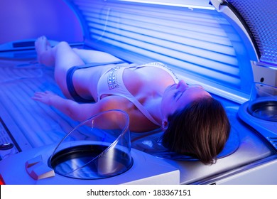 Attractive Woman Relaxing And Sunbathing On Tanning Bed.