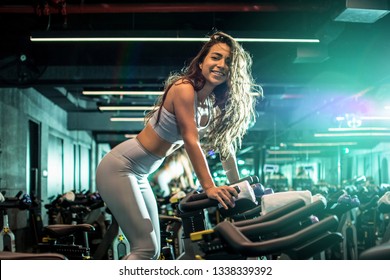 Attractive Woman Riding On The Spinning Bike At Gym