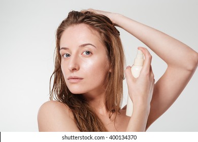 Attractive Woman Spraying Hairspray Isolated On A White Background