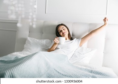 Attractive woman stretching in the bed at the morning