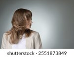 Attractive woman with stylish haircut on grey gradient background, space for text