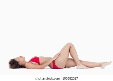 Attractive Woman In Swimsuit Lying Down Against A White Background