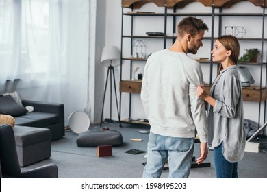 attractive woman talking with handsome man in robbed apartment - Shutterstock ID 1598495203