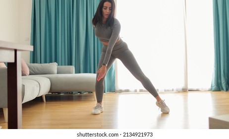 Attractive Woman Virtual Workout At Home Using Laptop. Fitness Workout Exercises Online Woman At Home. . Virtual Online Fitness Course At Home. Elastic Band Glutes Workout.