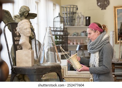 Attractive Woman Visiting An Antique Shop And Looking For Precious Nice Things