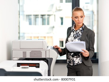 Attractive Woman Working On Copy Machine In Office