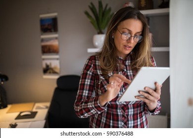 Attractive Woman Working On A Tablet In A Home Office.