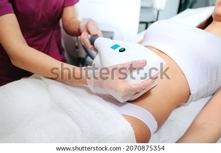 Attractive woman's abdomen getting Cool sculpting procedure for body slimming. Cryolipolyse and body contouring treatment, anti-cellulite and anti-fat therapy in beauty salon