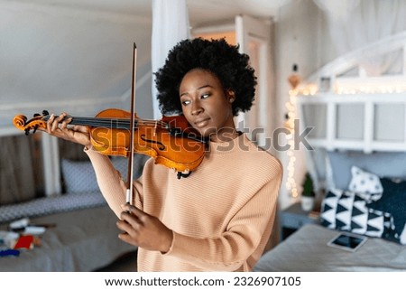 Attractive young african american woman musician plays the violin practicing musical instrument