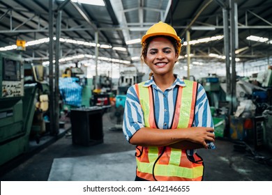 Attractive Young African Woman Smiling And Working Engineering In Industry.Portrait Of Young Female Worker In The Factory.Work At The Heavy Industry Manufacturing Facility Concept.