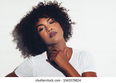 Attractive Young African Women With Curly Hair And An Attitude Standing Confidently Alone Against A White Background