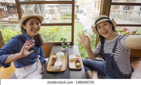 Attractive Young Asian Ladies Traveler Sitting In Japanese Style House Doing Chado Tea Ceremony Smiling Happily Saying Hello Hi Or Bye Waving Hand At Camera Video Call. Greeting Goodbye Body Language