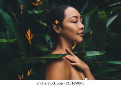 Attractive young Asian woman touching soft neck with clean and fresh skin - beauty and Cosmetics Concept, charming Korean female with closed eyes keeping healthy lifestyle spending dayspa at nature