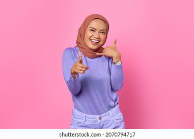 Attractive Young Asian Woman Wink Eye Pointing To You Make Call A Sign On Pink Background