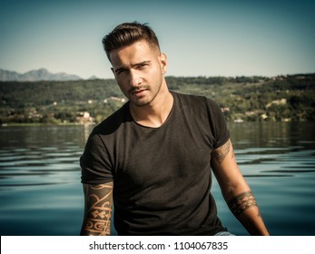 Attractive Young Athletic Man Standing In Water In Sea Or Lake, Wearing Black T-shirt