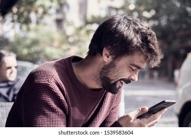 Attractive young bearded man using his smartphone in the cafe - Shutterstock ID 1539583604