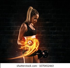 Attractive Young Blond Woman Doing Bodybuilding, Holding Fire Dumbbells. Concept Of Hard Work And Motivation, Dark Brick Wall Background. Very High Resolution Image