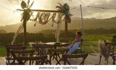 Attractive Young Bride In A Wedding White Dress. Wedding Decorations In Boho Style. Vintage String Lights Bulb Garlands Shining Above Chairs At Summer Rural Wedding.