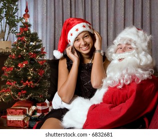 Attractive Young Brunette Sitting On Santa Claus' Lap