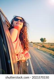 Attractive Young Brunette Woman Smiling And Enjoying The Wind Outside The Car - Happiness And Travel Concept For Happy And Cheerful White People