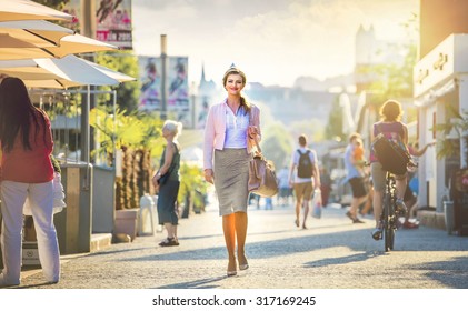 Attractive young business woman walking in the city